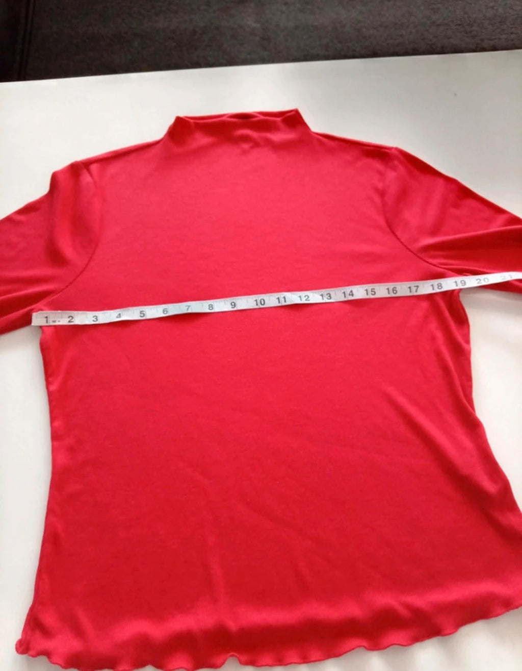 Sweaty Betty red ribbed long sleeve top with mock neck and lettuce-edge hem.