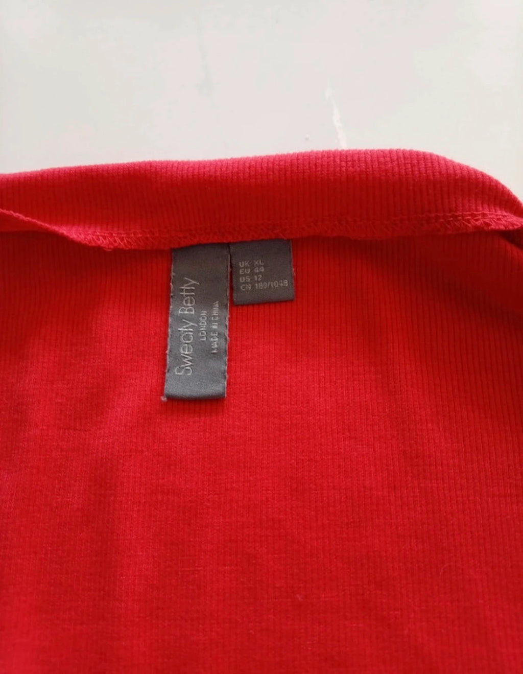 Sweaty Betty red ribbed long sleeve top with mock neck and lettuce-edge hem.