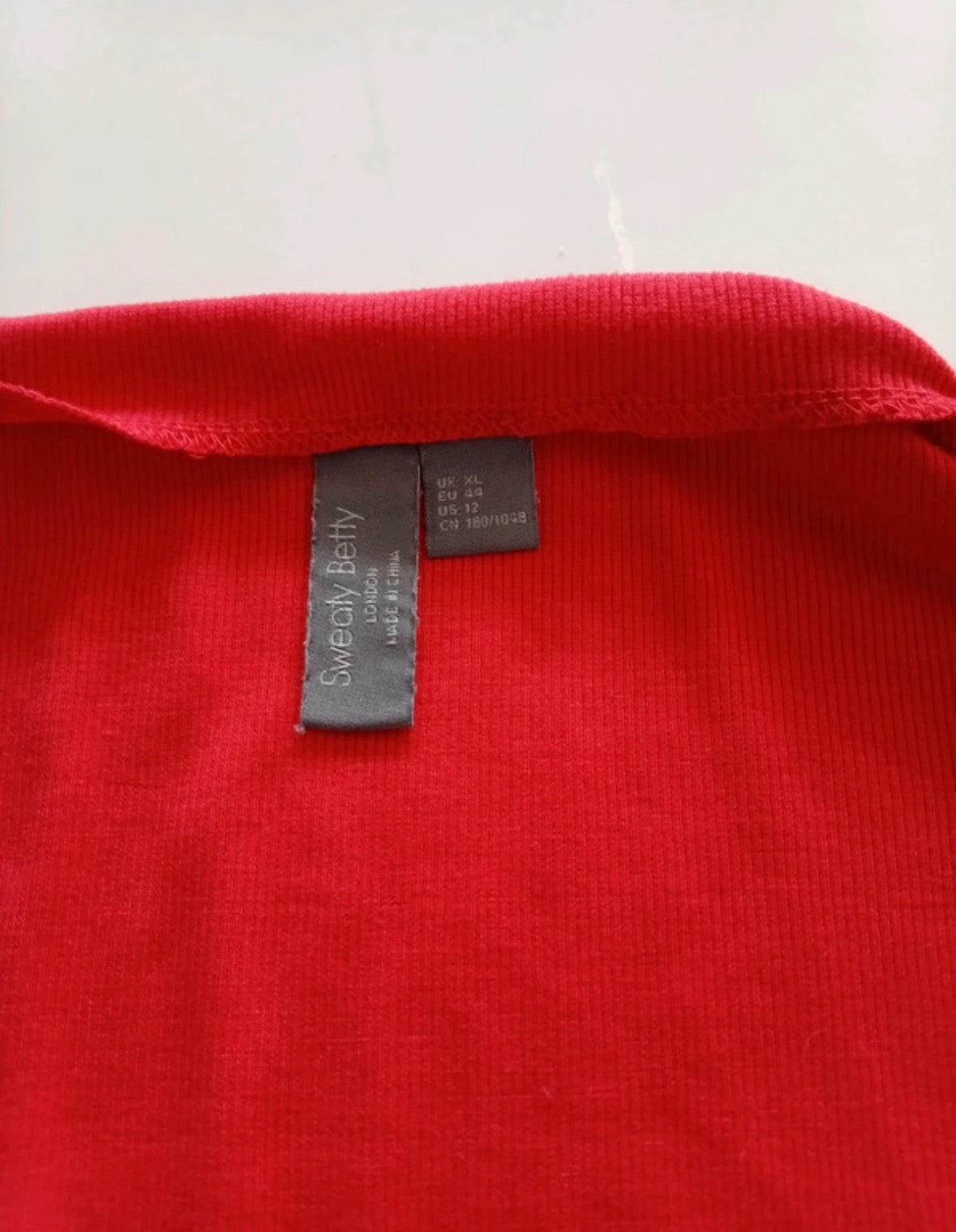Sweaty Betty red ribbed long sleeve top with mock neck and lettuce-edge hem.