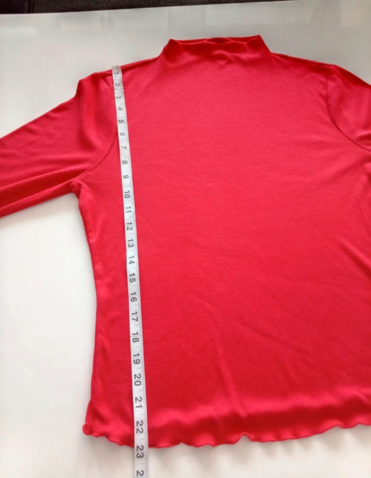 Sweaty Betty red ribbed long sleeve top with mock neck and lettuce-edge hem.