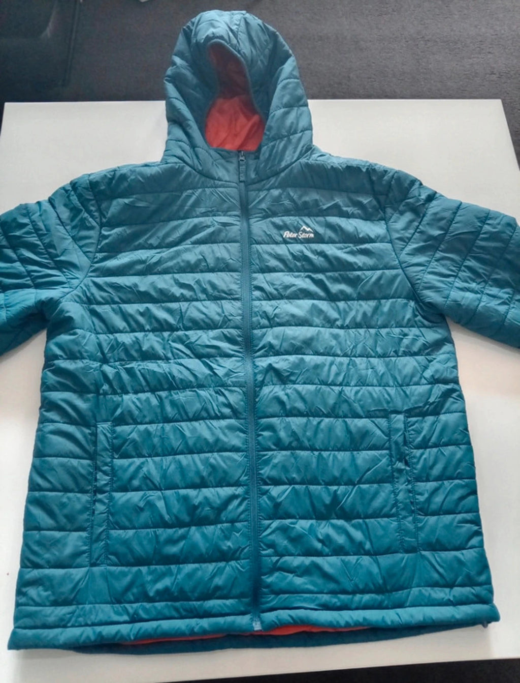Peter Storm teal blue puffer jacket with hood and contrasting orange lining.