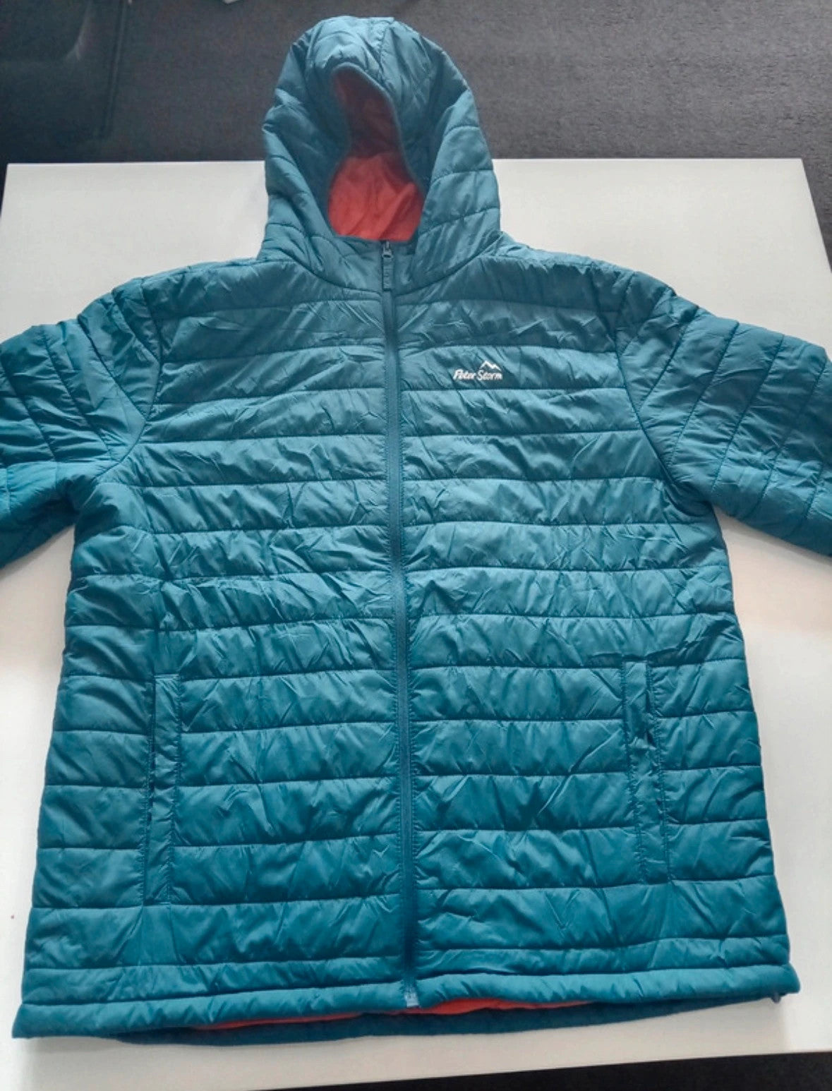 Peter Storm teal blue puffer jacket with hood and contrasting orange lining.