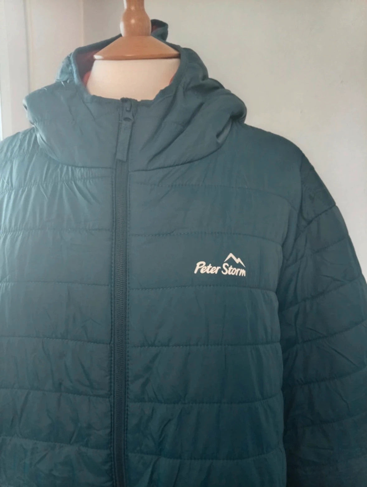 Peter Storm teal blue puffer jacket with hood and contrasting orange lining.