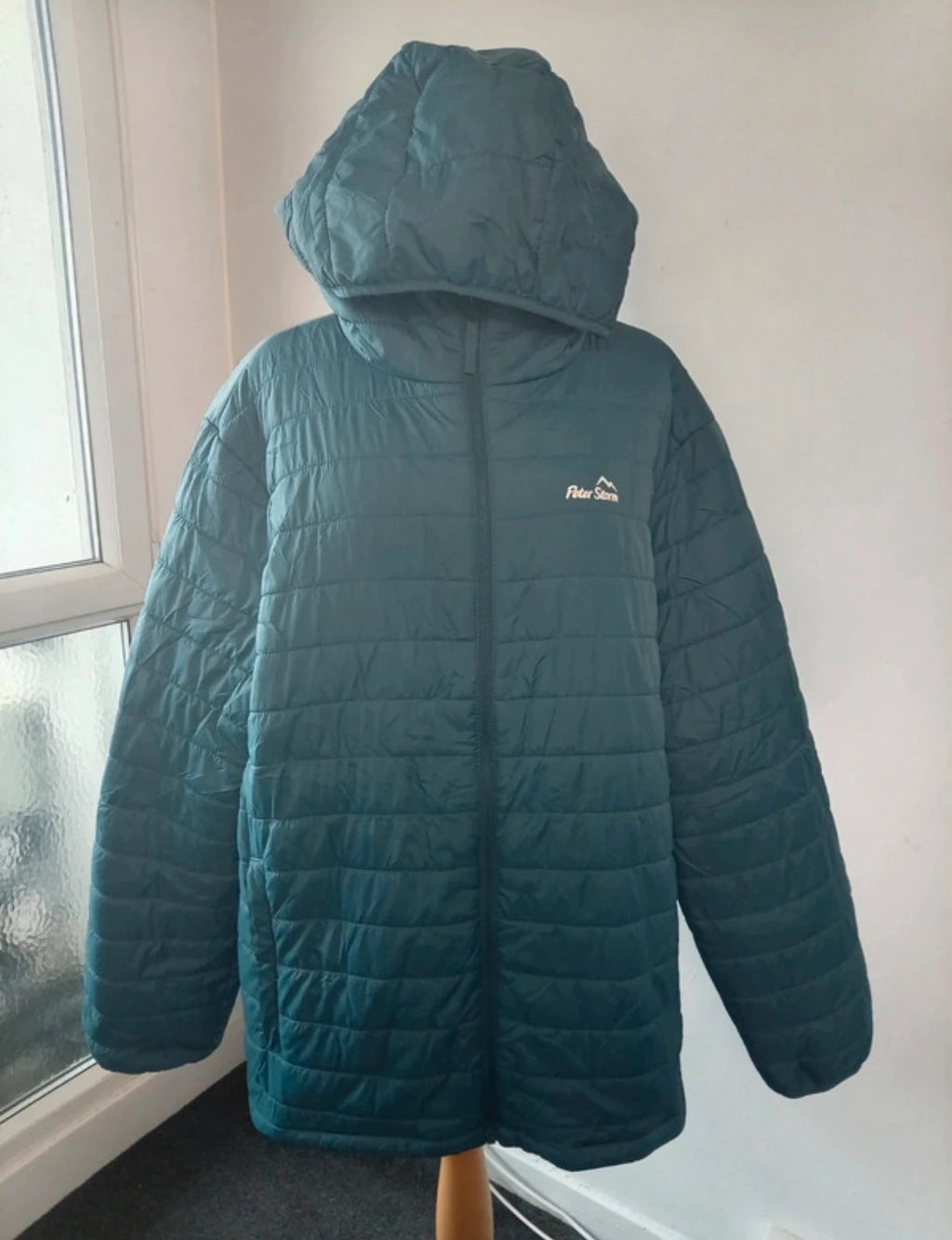 Peter Storm teal blue puffer jacket with hood and contrasting orange lining.