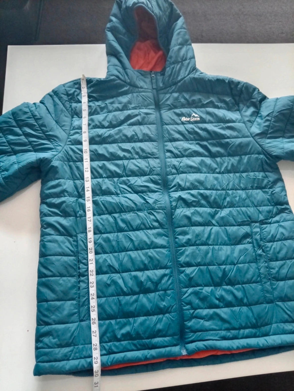 Peter Storm teal blue puffer jacket with hood and contrasting orange lining.
