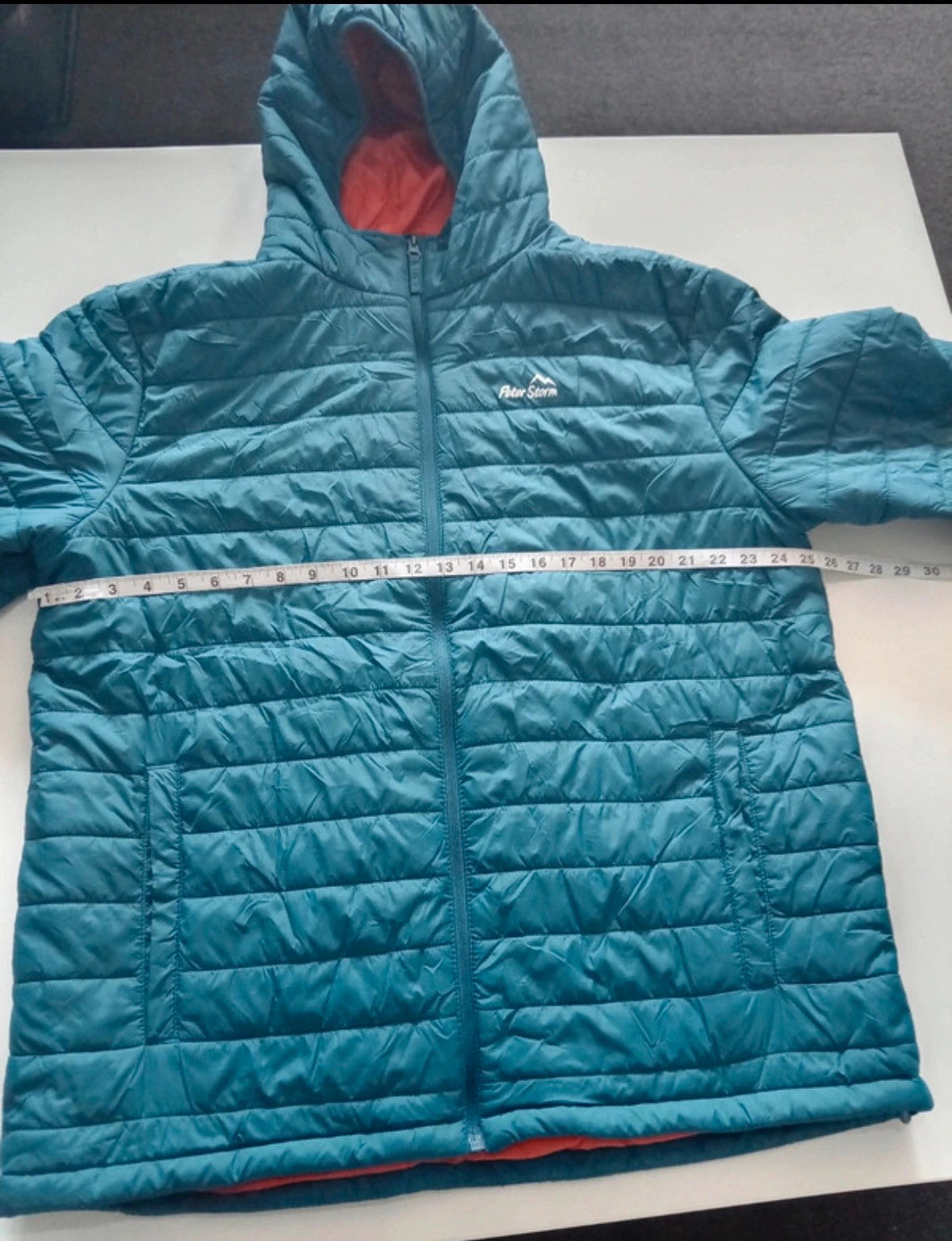 Peter Storm teal blue puffer jacket with hood and contrasting orange lining.